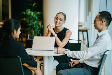 iş adamları modern ofiste dizüstü kullanarak proje tartışıyor 
