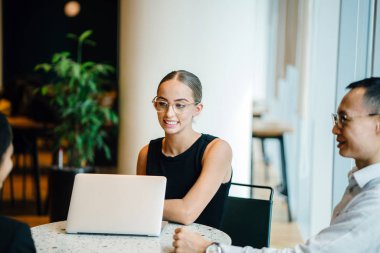 iş adamları modern ofiste dizüstü kullanarak proje tartışıyor 