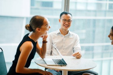 iş adamları modern ofiste dizüstü kullanarak proje tartışıyor 