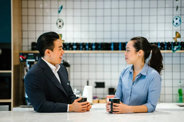 Proje iki iş adamları tartışırken masada oturan ve modern ofis mutfakta kahve içme