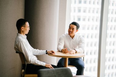 modern ofis masada oturan ve birlikte çalışan iş adamları