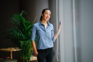 yeşil bitki ile modern ofis ayakta gülümseyerek emin Asya iş kadını
