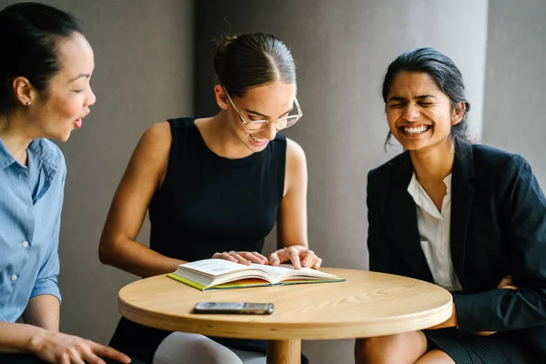 okuma kitap kafede masada oturan gülümseyen üç genç kadın portresi