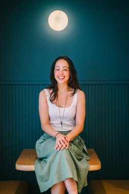 modern ofis masada oturan gülümseyen genç ve çekici bir kadın 