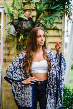 Açık yeşil yaprakları ile arka plan üzerinde uzun saçlı güzel şık kadın portresi