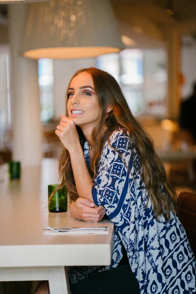 Kafede oturan uzun saçlı genç çekici kadın portresi 