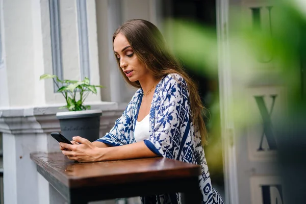 bokeh yeşil yaprakları ile tencerede çiçekli masada oturan uzun saçlı güzel şık kadın portresi