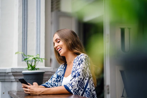 bokeh yeşil yaprakları ile tencerede çiçekli masada oturan uzun saçlı güzel şık kadın portresi