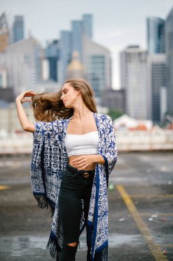 arka plan üzerinde gökdelenler ile şehir sokak üzerinde onu uzun saçlı ayakta dokunmadan poz güzel şık kadın