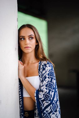 Üst ve eşarp beton arka plan karşı giyen güzel genç kadın portresi