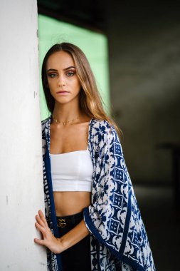 Üst ve eşarp beton arka plan karşı giyen güzel genç kadın portresi