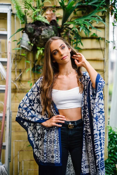 Açık yeşil yaprakları ile arka plan üzerinde uzun saçlı güzel şık kadın portresi