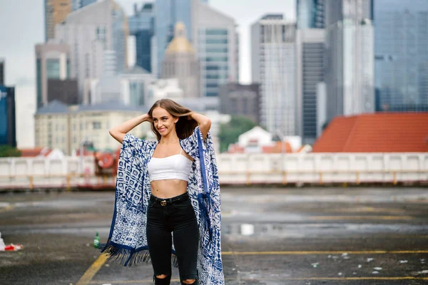 arka plan üzerinde gökdelenler ile şehir sokak üzerinde onu uzun saçlı ayakta dokunmadan poz güzel şık kadın