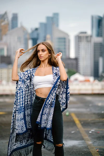 arka plan üzerinde gökdelenler ile şehir sokak üzerinde onu uzun saçlı ayakta dokunmadan poz güzel şık kadın