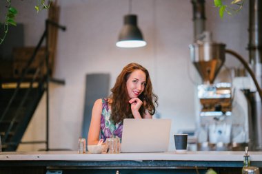düşünceli işkadını kafede masada oturan laptop çalışma