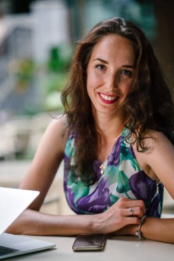 laptop ve smartphone ile masada oturan işkadını portresi