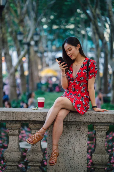 Молодая Женщина Красном Платье Смартфоном Сидит Улице — стоковое фото