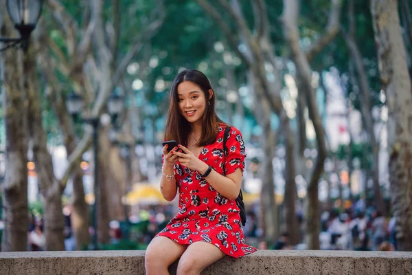 Молодая Женщина Красном Платье Смартфоном Сидит Улице — стоковое фото
