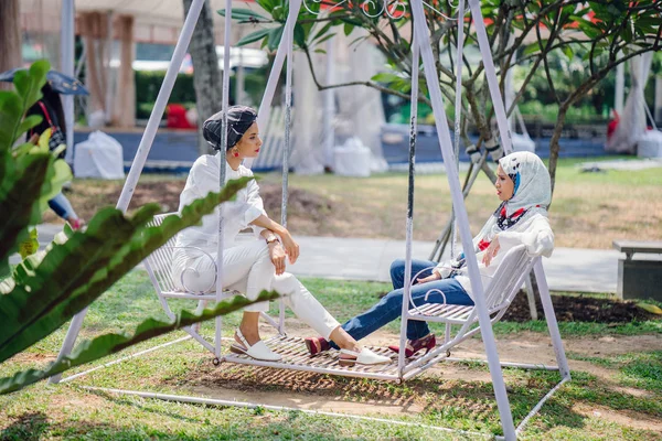 Salıncak üzerinde baş eşarp iki genç ve çekici Müslüman kadın 