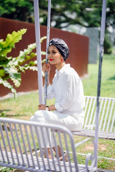 一个年轻的穆斯林妇女戴头巾 的肖像 她坐在秋千上 — 图库照片