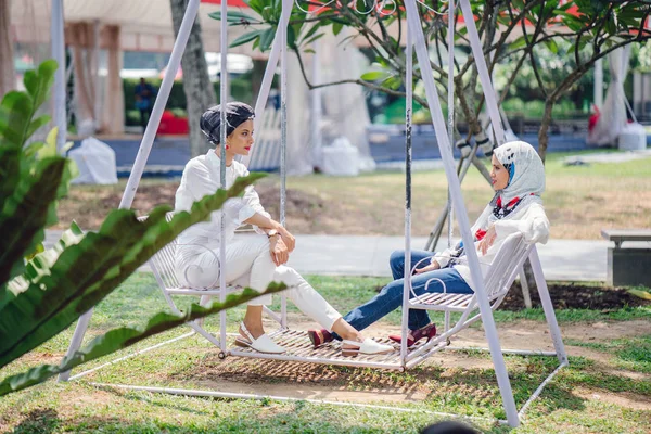 Salıncak üzerinde baş eşarp iki genç ve çekici Müslüman kadın 