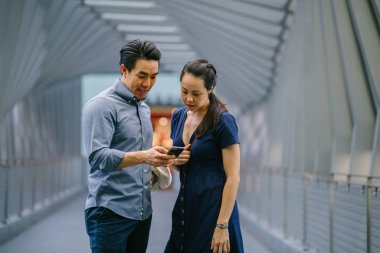 Bir Asya Çin portresi çift bir tarihte, hafta sonu. Biri Genç, yakışıklı ve iyi giyimli ve smartphone yönde arayan kadın
