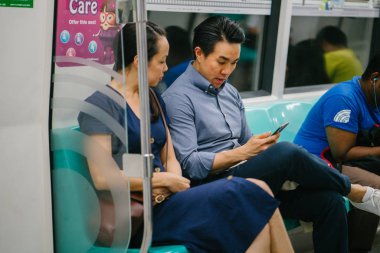 Metroda oturan genç Asyalı çift.