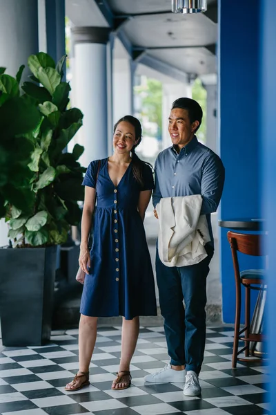 Portrait of an Asian Chinese couple on a date over the weekend. The man is young, handsome and well-dressed and the woman is wearing an elegant summer dress.