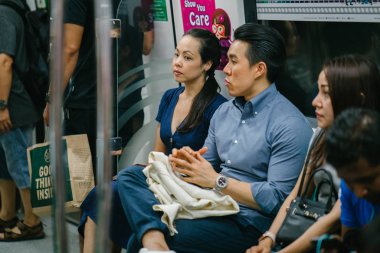 Metroda oturan genç Asyalı çift.