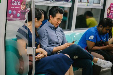 Metroda oturan genç Asyalı çift.