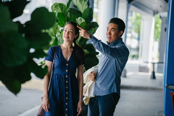 Portrait of an Asian Chinese couple on a date over the weekend looking somewhere