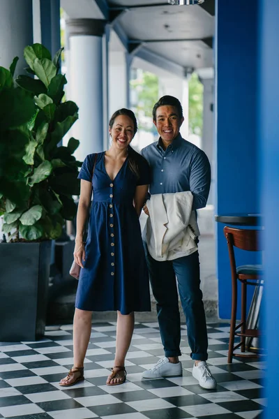 Portrait of an Asian Chinese couple on a date over the weekend. The man is young, handsome and well-dressed and the woman is wearing an elegant summer dress.