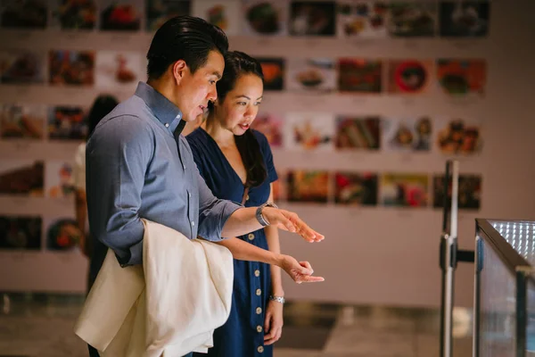 Young Chinese Asian Couple Contemplating Display Cakes Retail Mall Thinking — Stock Photo, Image