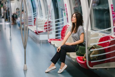 Asya tatil sırasında bir trende oturan genç ve güzel Japon Asya turist kadın. O sevimli, çekici ve mutlulukla gülümsüyor gibi onun koltukta rahatlatır.