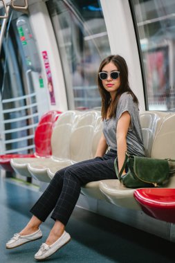 Asya tatil sırasında bir trende oturan genç ve güzel Japon Asya turist kadın. O sevimli, çekici ve mutlulukla gülümsüyor gibi onun koltukta rahatlatır.