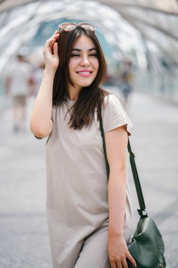 Mutlu çekici genç Asyalı kadın sokakta yürüme 