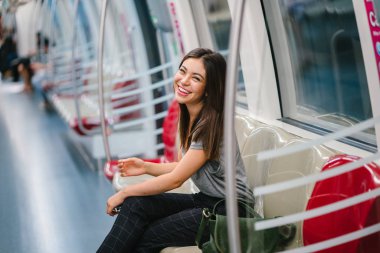 Asya tatil sırasında bir trende oturan genç ve güzel Japon Asya turist kadın. O sevimli, çekici ve mutlulukla gülümsüyor gibi onun koltukta rahatlatır.