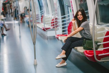 Asya tatil sırasında bir trende oturan genç ve güzel Japon Asya turist kadın. O sevimli, çekici ve mutlulukla gülümsüyor gibi onun koltukta rahatlatır.