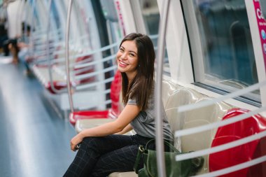Asya tatil sırasında bir trende oturan genç ve güzel Japon Asya turist kadın. O sevimli, çekici ve mutlulukla gülümsüyor gibi onun koltukta rahatlatır.