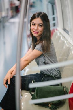 Asya tatil sırasında bir trende oturan genç ve güzel Japon Asya turist kadın. O sevimli, çekici ve mutlulukla gülümsüyor gibi onun koltukta rahatlatır.