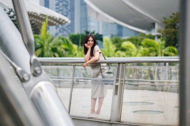 Mutlu çekici genç Asyalı kadın sokakta yürüme 