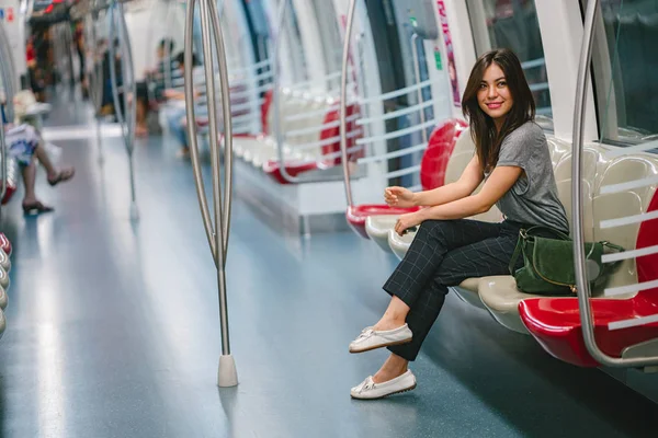 young and pretty Japanese Asian tourist woman sitting on a train in Asia while on vacation. She is cute, attractive and is smiling happily as she relaxes in her seat.