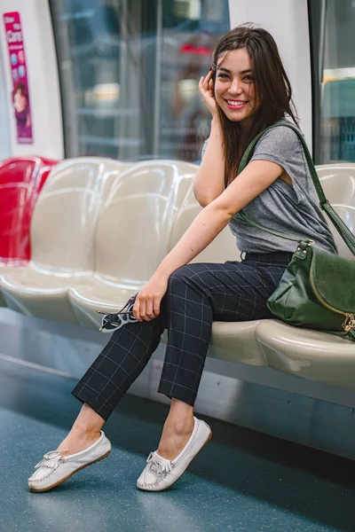 一位年轻漂亮的日本亚洲旅游妇女 坐在亚洲的火车上度假 她很可爱 很有魅力 当她在座位上放松时 她笑得很开心 — 图库照片