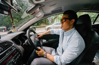 Genç adam araba kullanıyor.