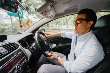 Genç adam araba kullanıyor.