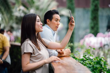 Genç çift akıllı telefonuyla selfie çekiyor.