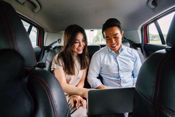 つの若いアジア ビジネス人々 車の後部座席に座っているし その先に彼らは予約乗車乗車出身アプリケーション経由で運転されます — ストック写真