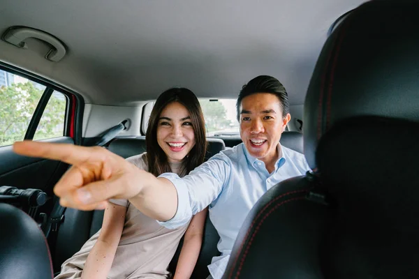Beautiful young asian couple showing direction to driver