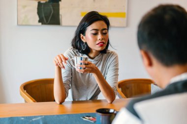 Genç bir sabah kahvelerini birlikte sabah işe gitmeden zevk Malay evli. Bir başkasına konuşuyorlar 