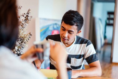 Genç bir sabah kahvelerini birlikte sabah işe gitmeden zevk Malay evli. Bir başkasına kahve onların rahat düz birlikte konuşuyorlar.